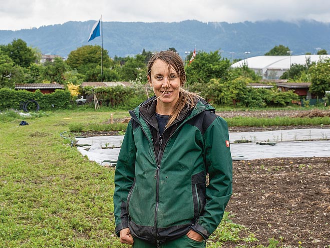 Portrait von Rahel Fuchs, Gärtnerin bei der Solawi Pura Verdura vor einem Gemüseacker