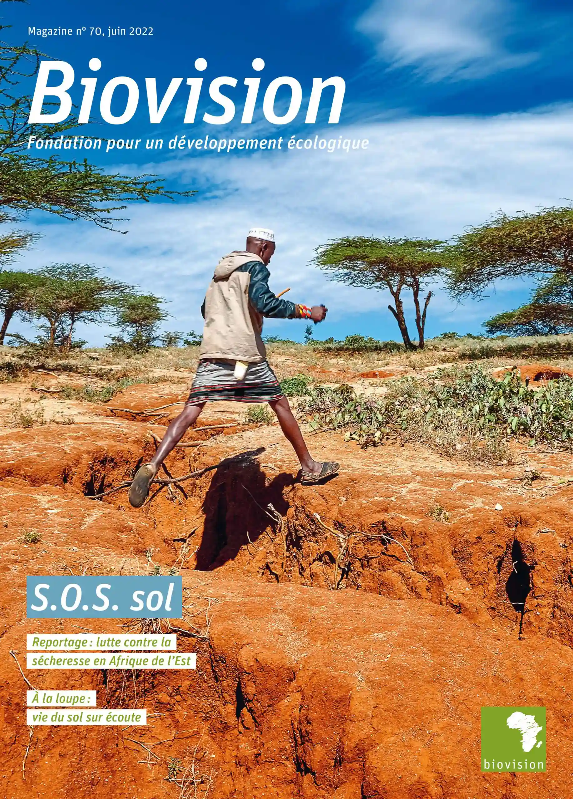 Das Titelbild des Biovision-Magazins zeigt einen Mann, der über einen tiefen Graben in der roten Erde springt.