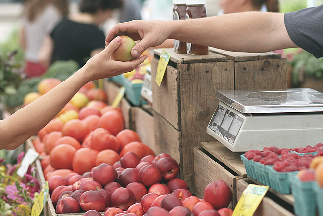 Einkaufssituation auf dem Bauernmarkt , Auswahl eines Apfels
