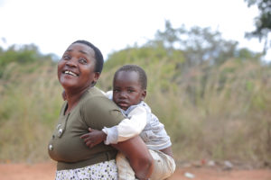 Femme portant son petit-fils dans son dos au Malawi en Afrique