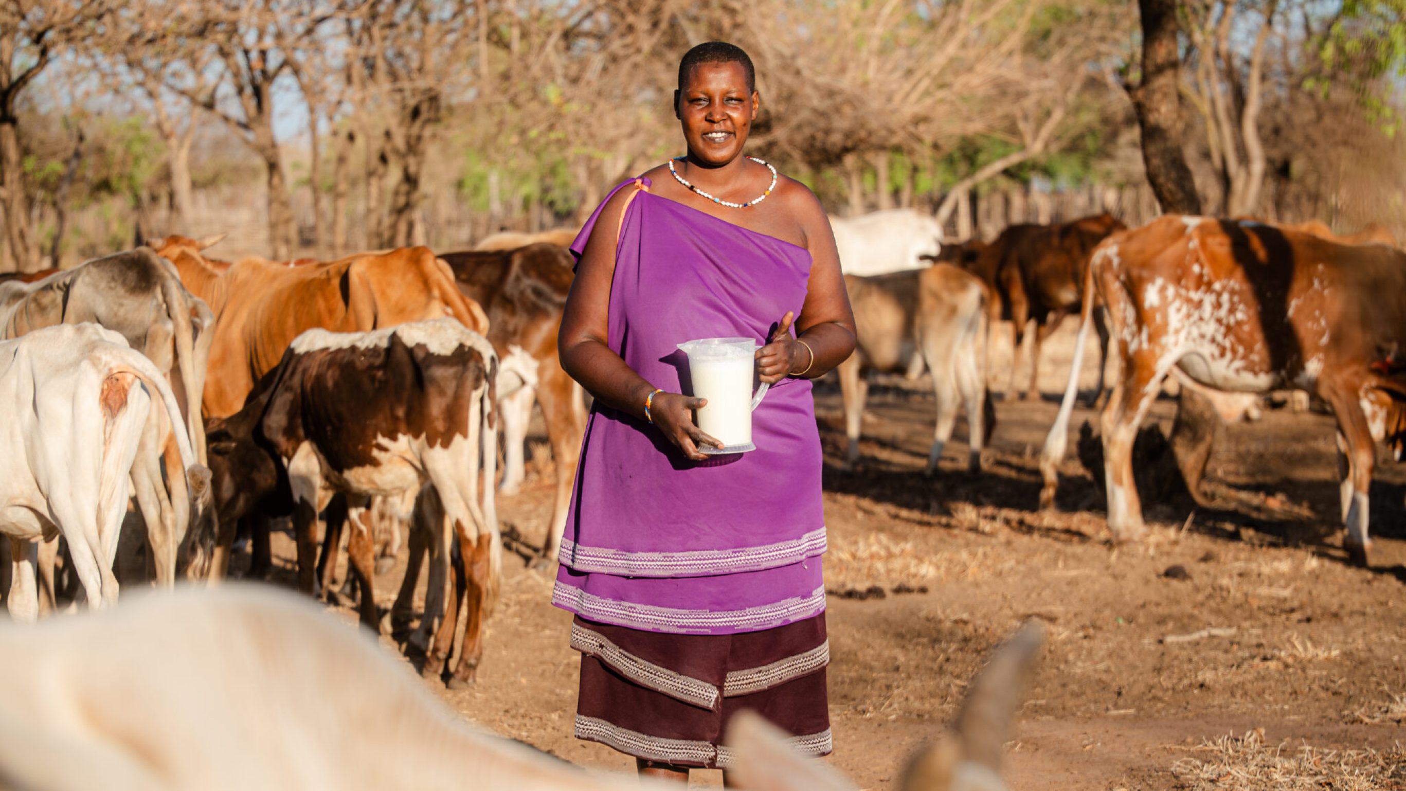 Pendo Ndemo Simangio zeigt stolz, wie ihre Tiere auch in Dürrezeiten Milch geben.
